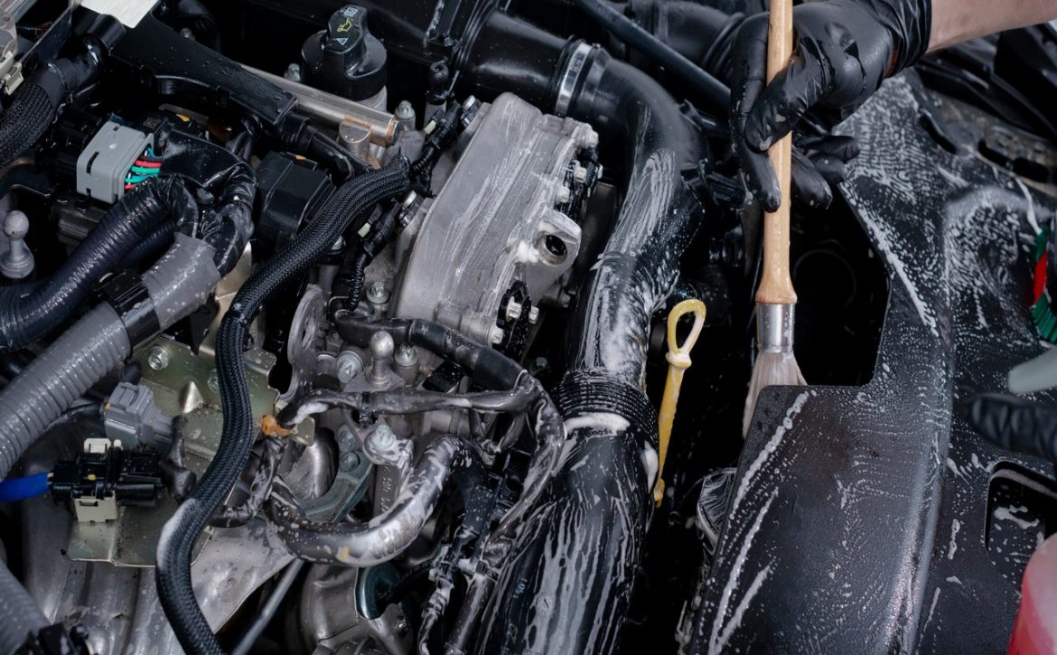 Car detailing maintaince, cleaning engine with the foam and a brush