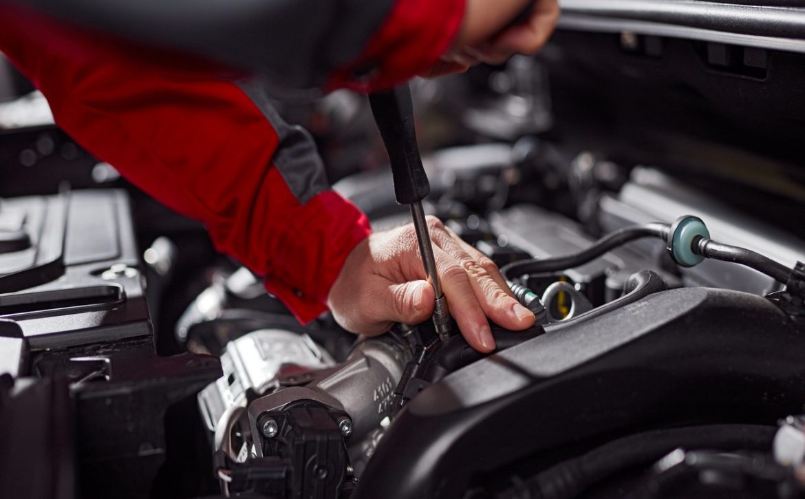 Crop technician fixing car engine
