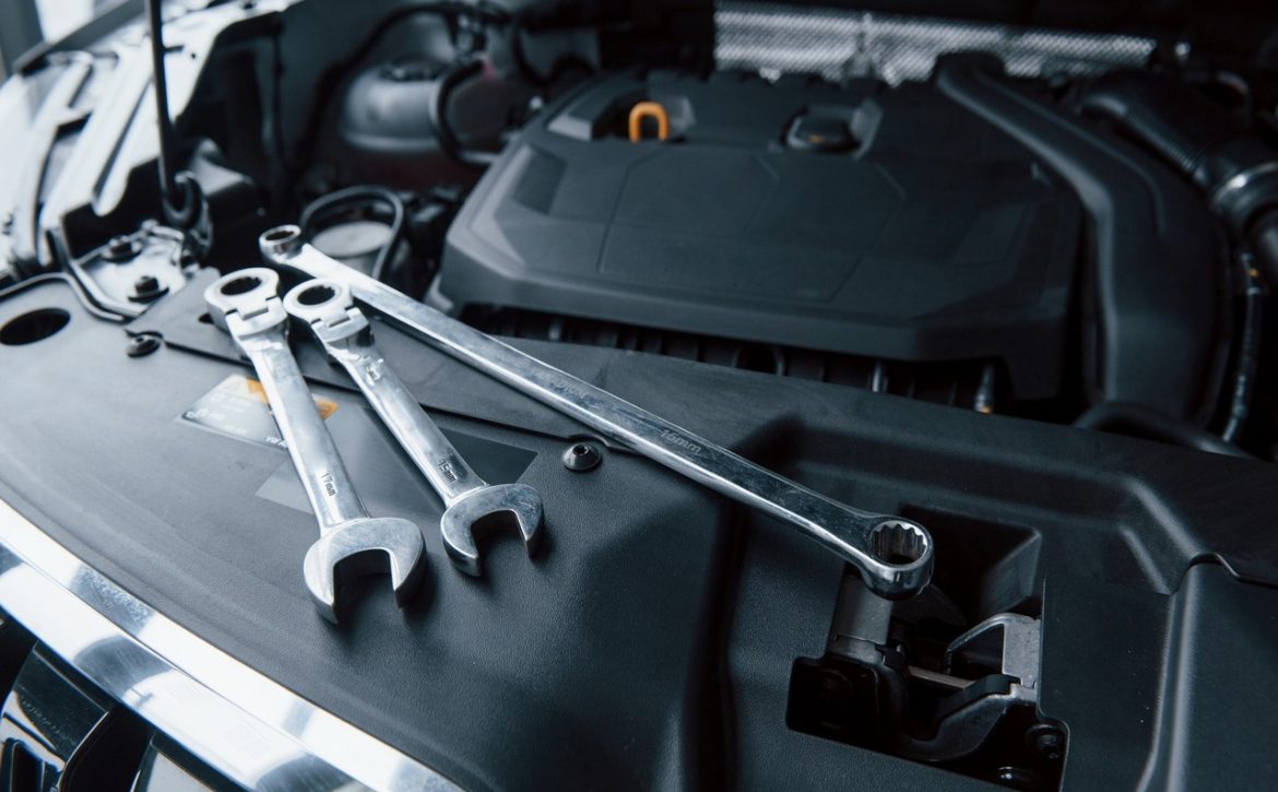 Group of objects. Repair tools lying down on the engine of automobile under the hood